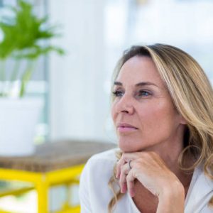 Close-up of thoughtful mature woman sitting in restaurant
